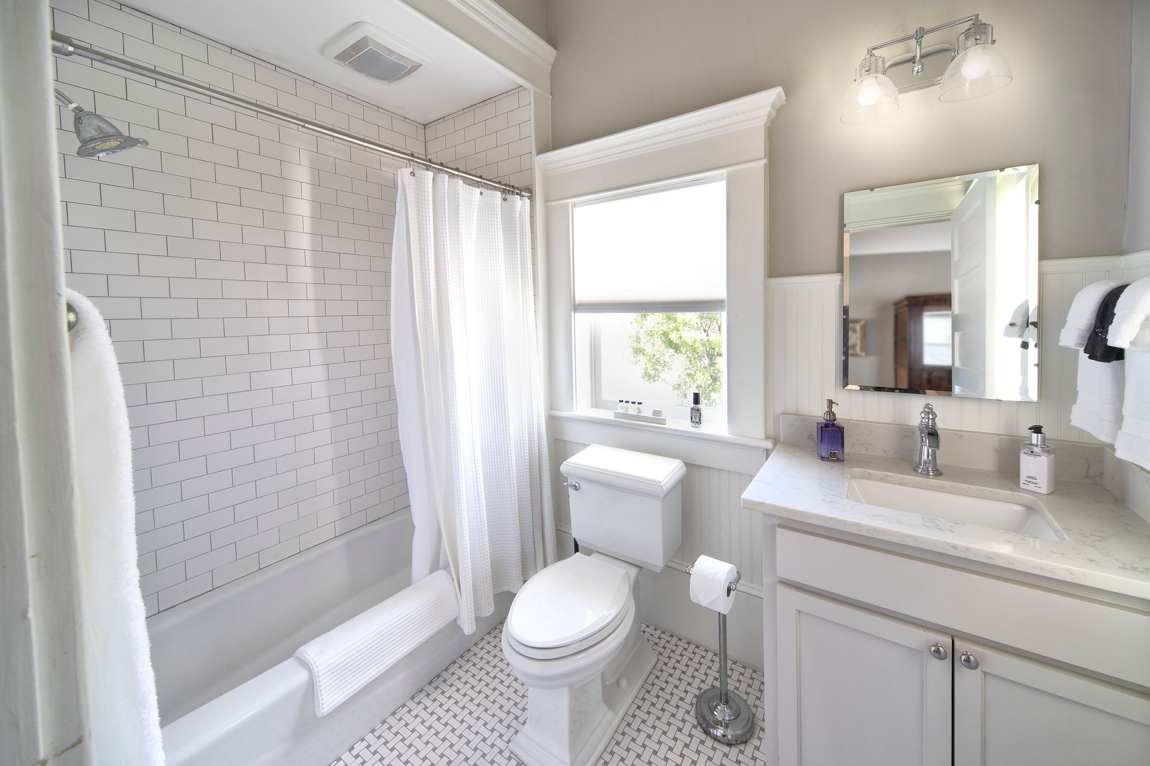 Ein Badezimmer mit Dusche, Toilette, Waschbecken und Spiegel.