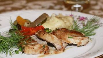 Un plato con pescado a la parrilla, puré de papas y verduras.