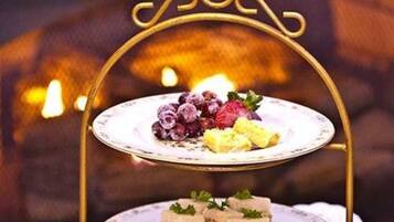 Un présentoir à desserts avec deux plateaux : l’un garni de fruits, l’autre de desserts à étages.