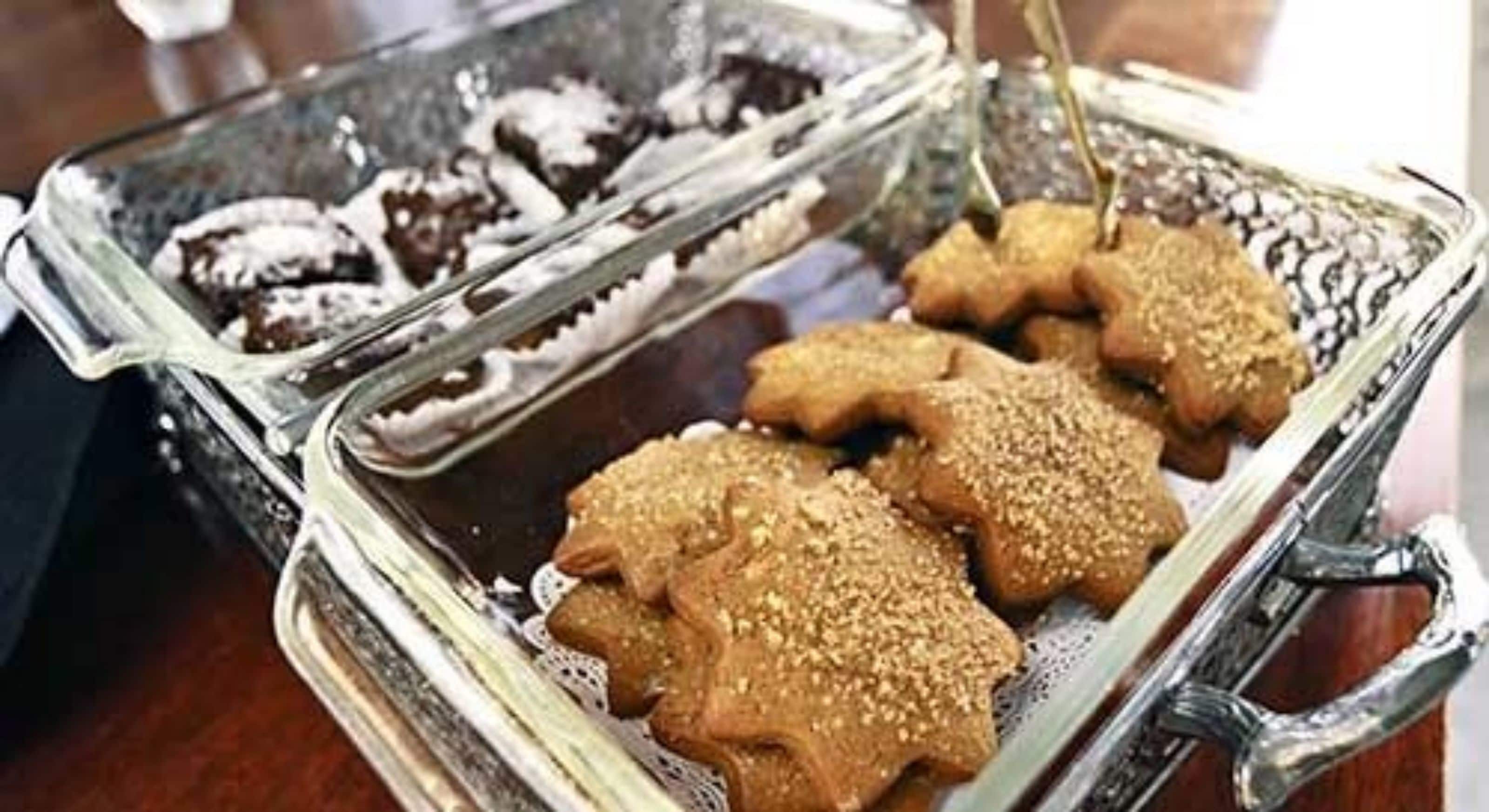A tray of cookies with sesame seeds on a glass container.