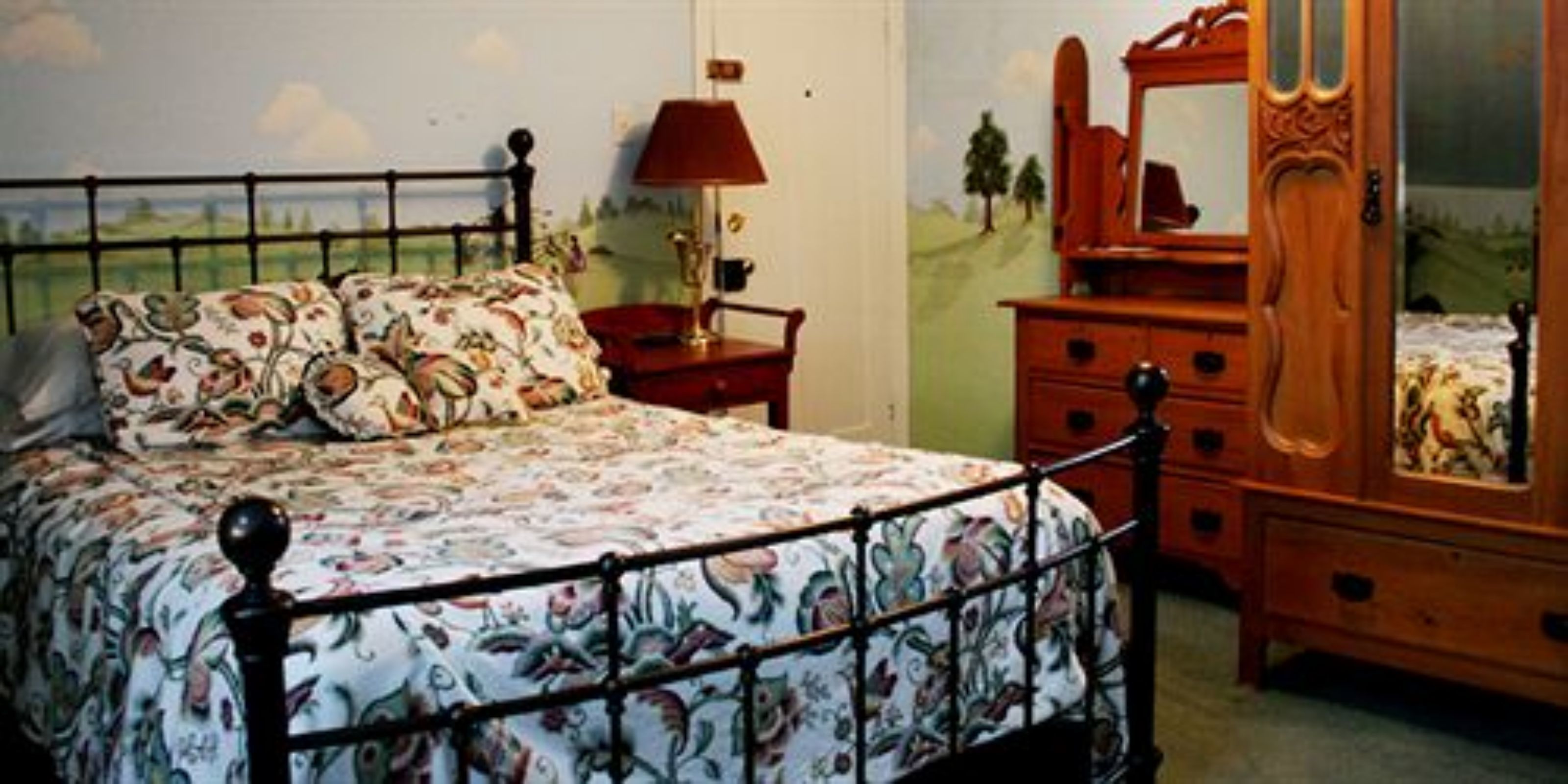 A bedroom with a bed, a dresser, and a nightstand.