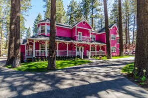 A pink house with a porch, surrounded by trees. - Apples Bed & Breakfast (Big Bear Lake)