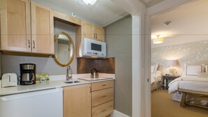 A compact hotel room with a kitchenette, including a microwave, kettle, and coffee maker. - North Bridge Inn (Concord)