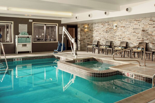 A pool area with a tiled floor, a hot tub, and lounge chairs. - Fairfield Inn & Suites by Marriott Waterbury Stowe (Waterbury)