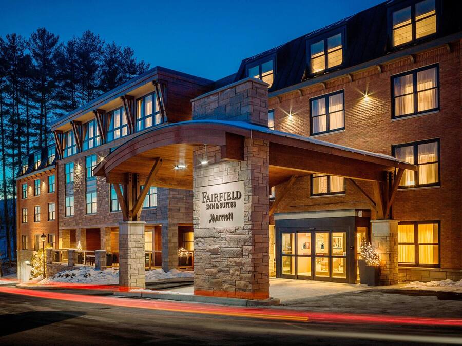 A multi-story hotel with a stone facade, large windows, and a marquee sign.