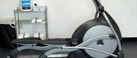 An exercise machine, a wall clock, and a sign with safety instructions.