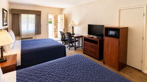 A hotel room with two beds, a desk, a TV, a microwave, and a wardrobe. - Segovia Lodge Junction TX I -10 (Junction)