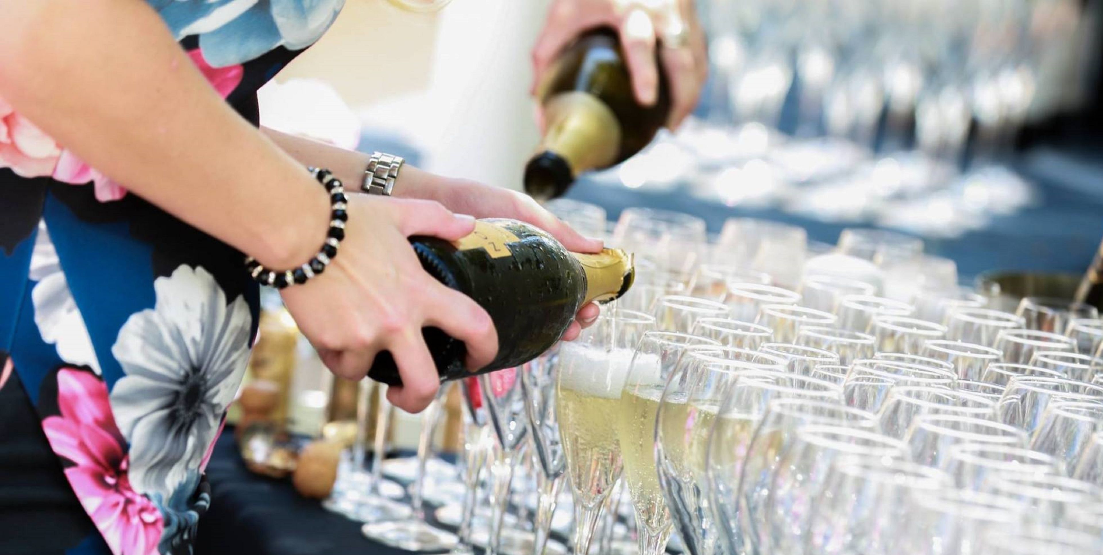 Une personne qui verse du champagne dans un verre.