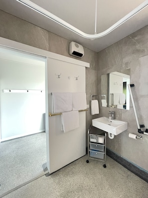 Habitación superior con 2 camas individuales, con acceso para personas discapacitadas | Baño | Regadera, amenidades de baño gratuitas, secadora de cabello, toallas