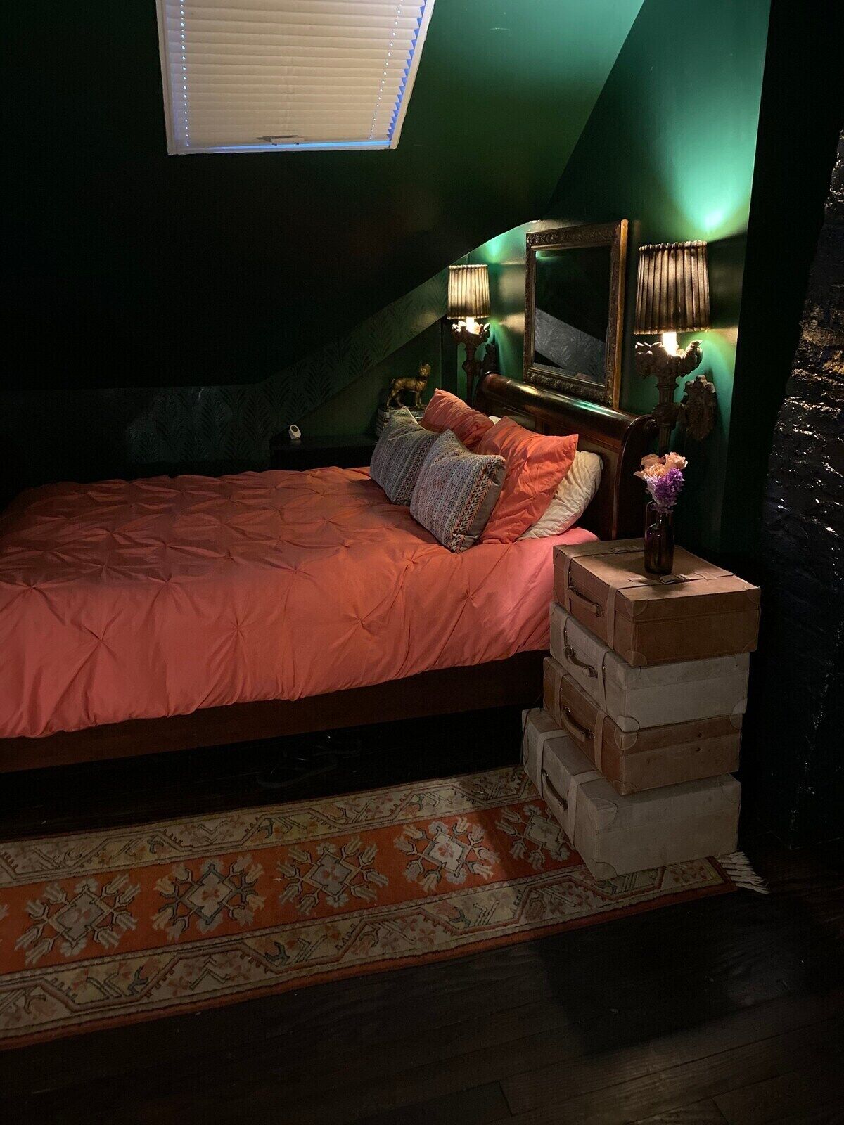 Un dormitorio con una cama, una mesita de noche, un espejo y una ventana.