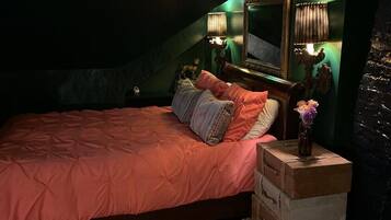 Un dormitorio con una cama, una mesita de noche, un espejo y una ventana.