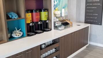 A modern kitchen area with a coffee station, decorative items, and a sign about a home guarantee.