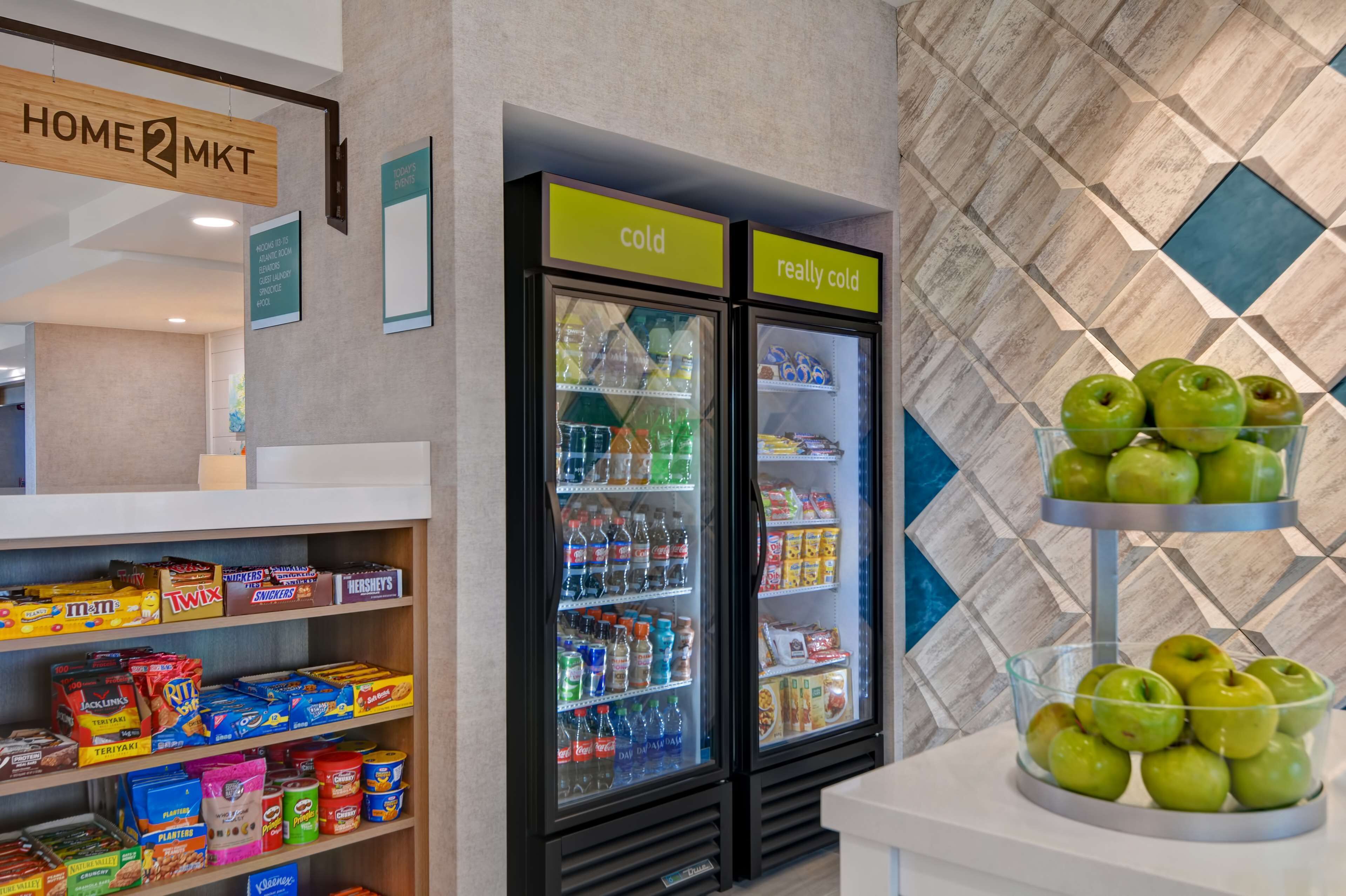 Uma área de distribuição automática com lanches e bebidas, incluindo uma exposição de maçãs verdes.