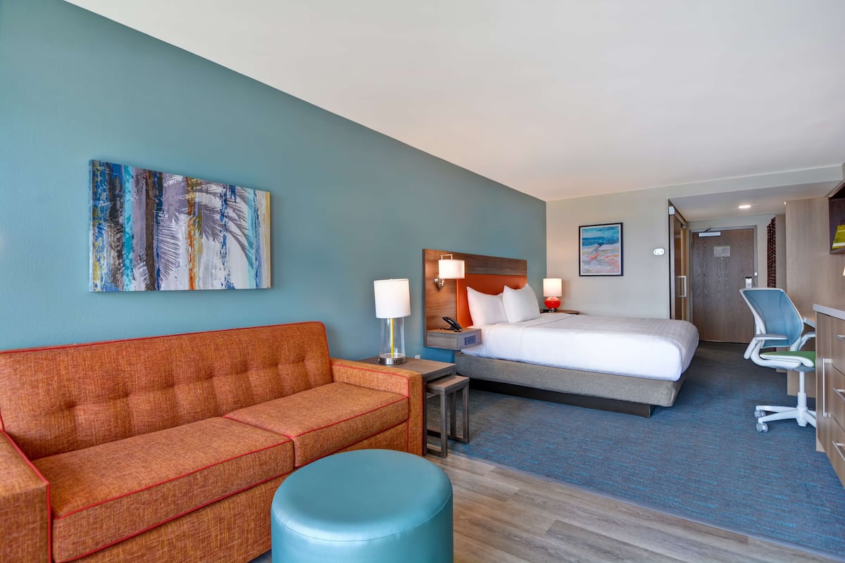 Une chambre d’hôtel avec un lit, un canapé, un bureau et une chaise.