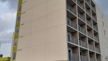 A multi-story hotel with a sign reading "HOME 2" and "Suites by Hilton". It features a modern architectural design with balconies on each floor.