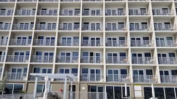 A multi-story hotel with balconies, outdoor seating, and a pool area.