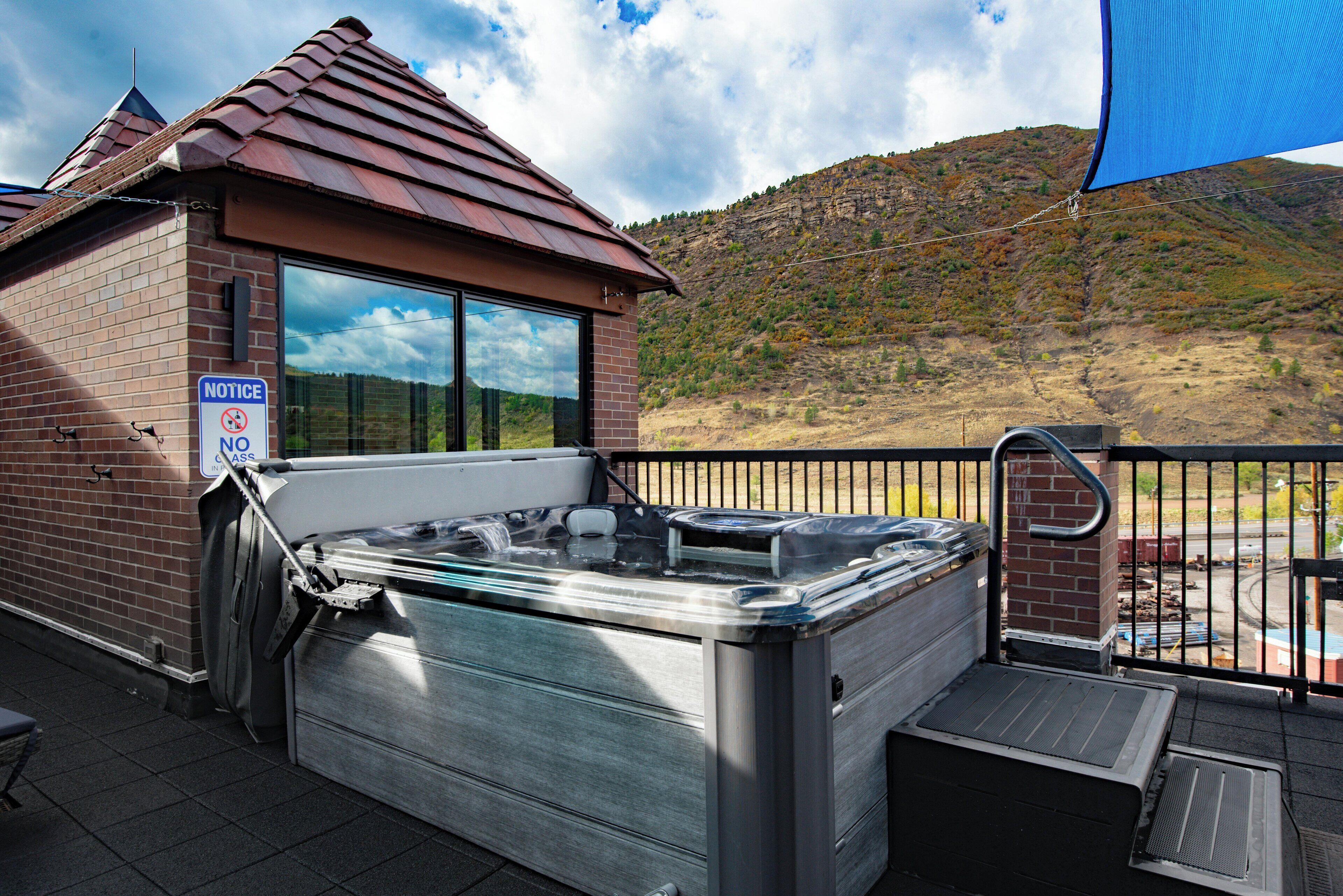 Un jacuzzi en un balcón con vistas a un paisaje montañoso.
