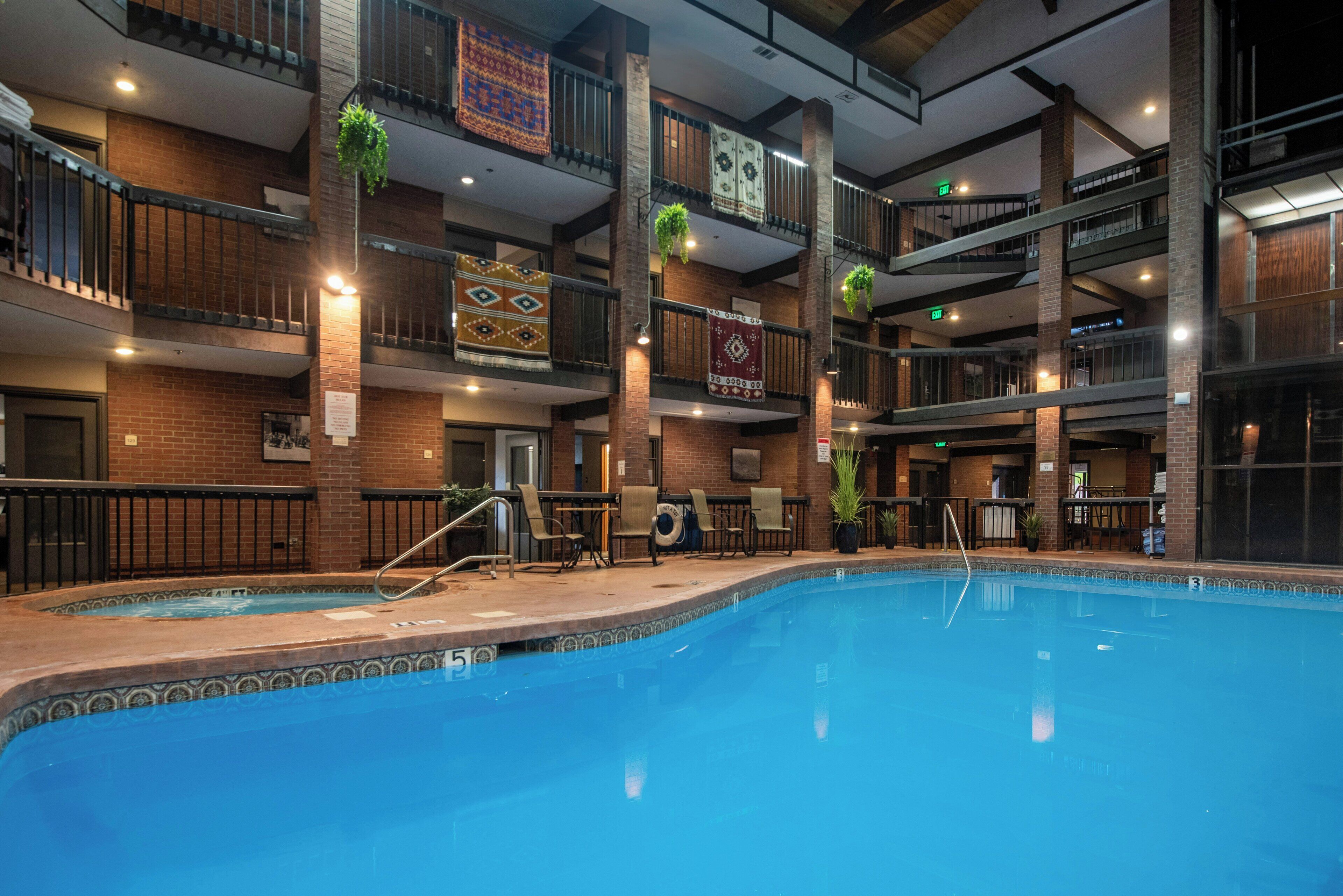 A multi-level indoor pool area with a central pool, multiple balconies, and seating areas.