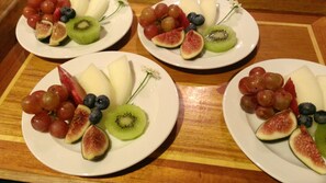 Trois assiettes de fruits sur une table en bois.