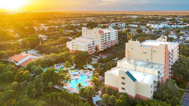 Un resort con varias construcciones, piscina y vegetación circundante.