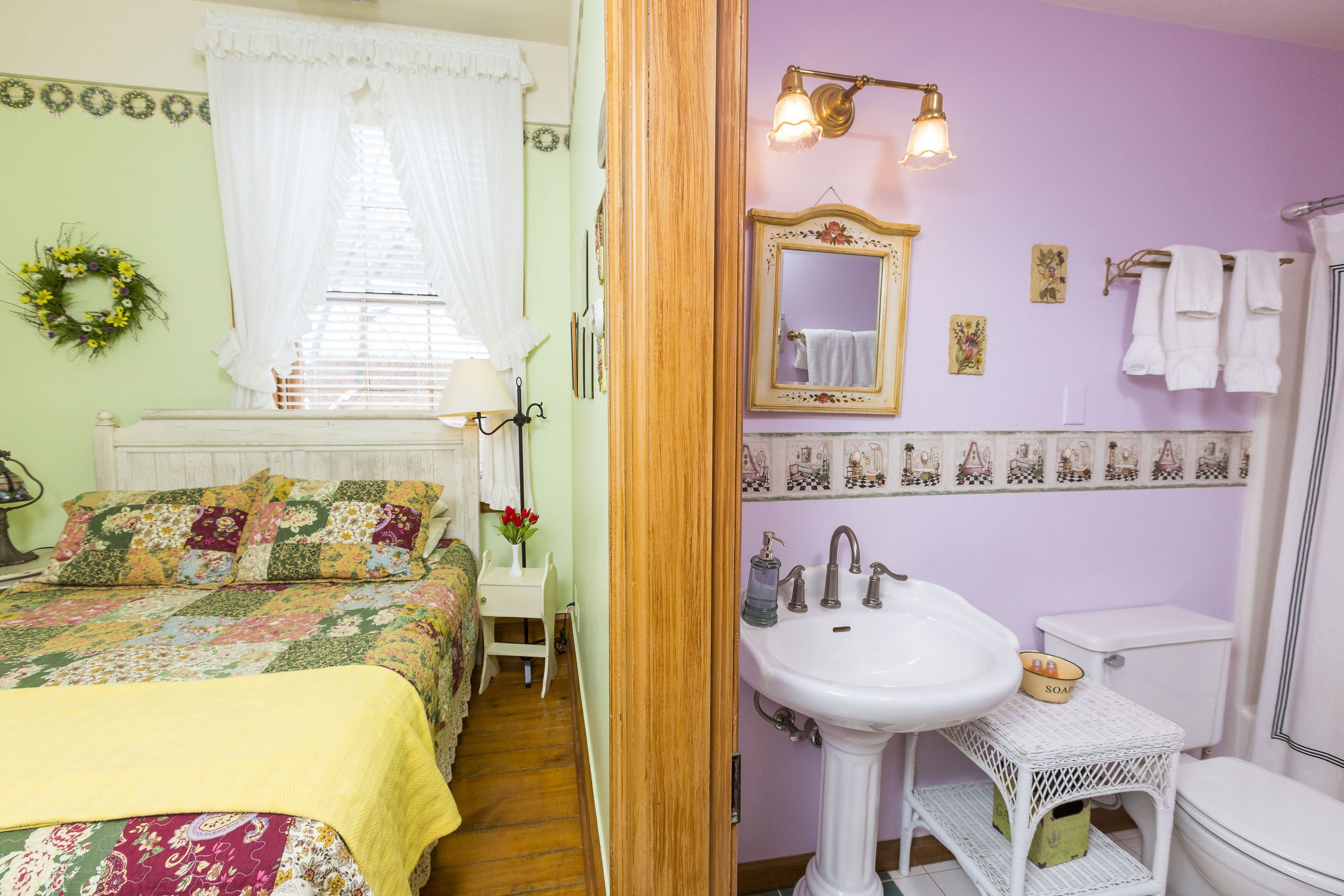 A bedroom with a bed, a bedside table, and a window with curtains.