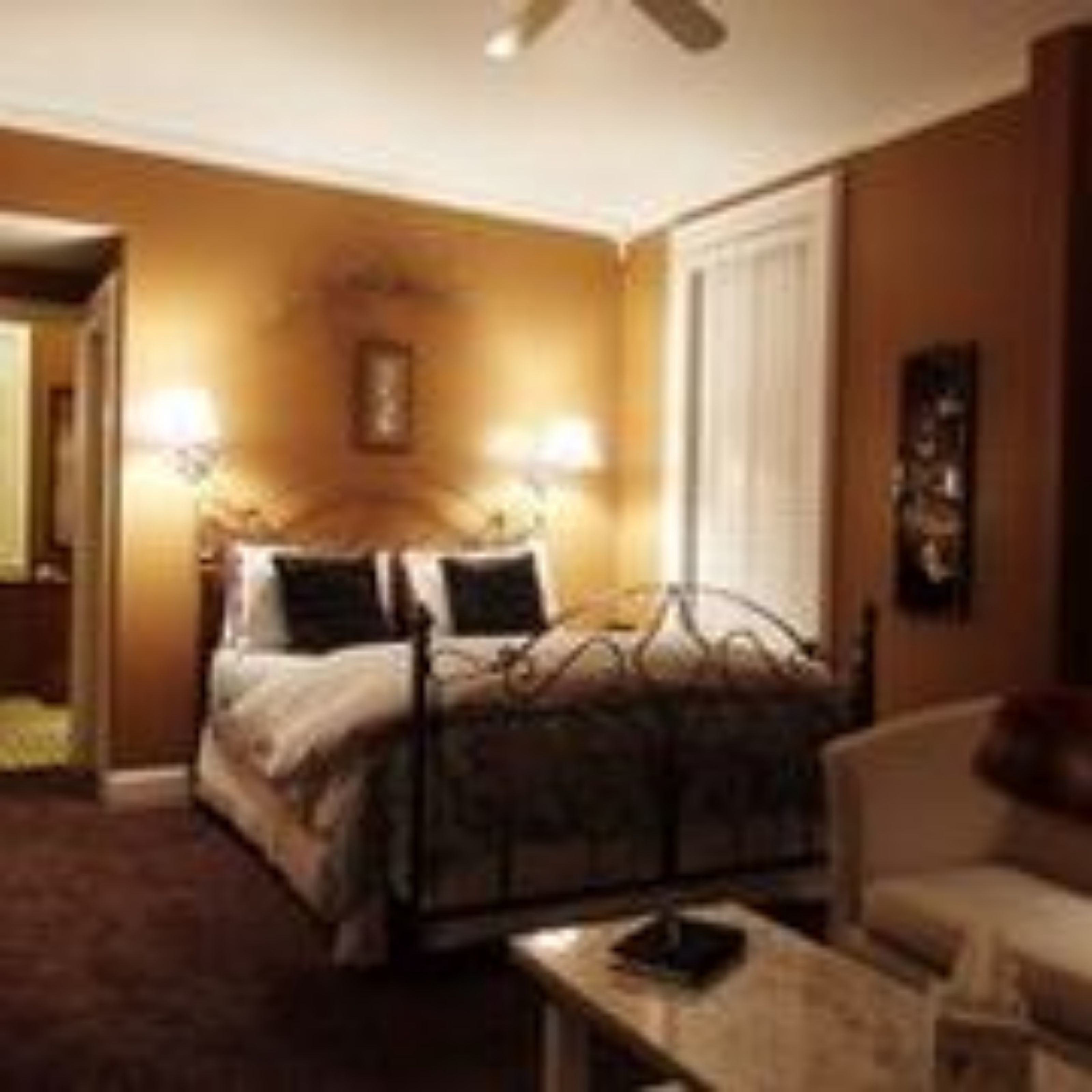 Una habitación de hotel con cama, lámparas de noche, escritorio y una silla.