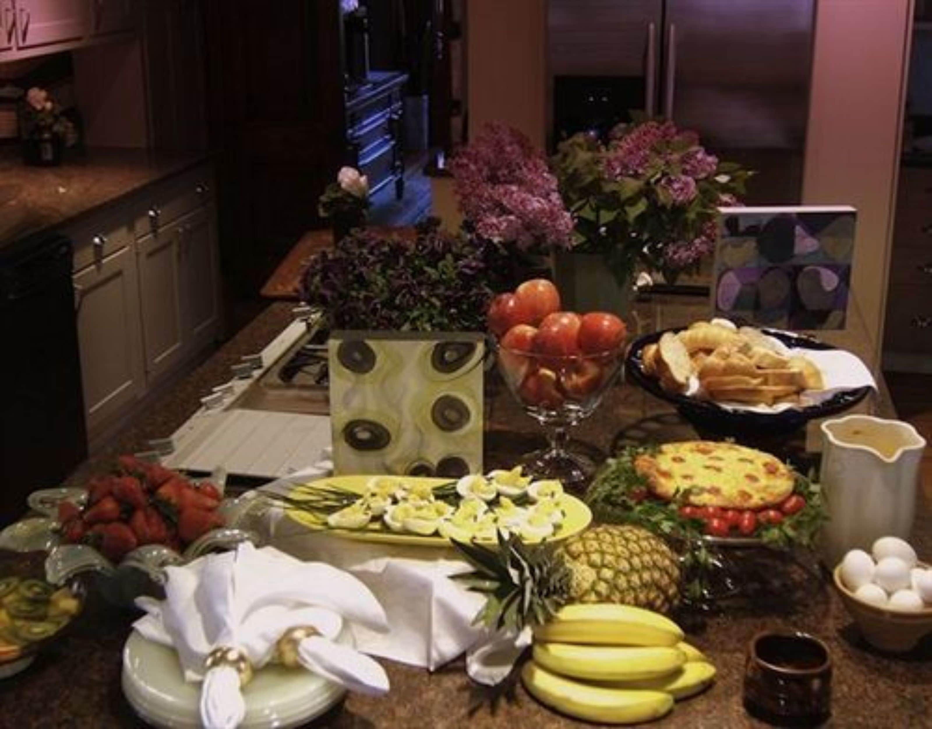 Una encimera de cocina con diversos alimentos y un refrigerador al fondo.
