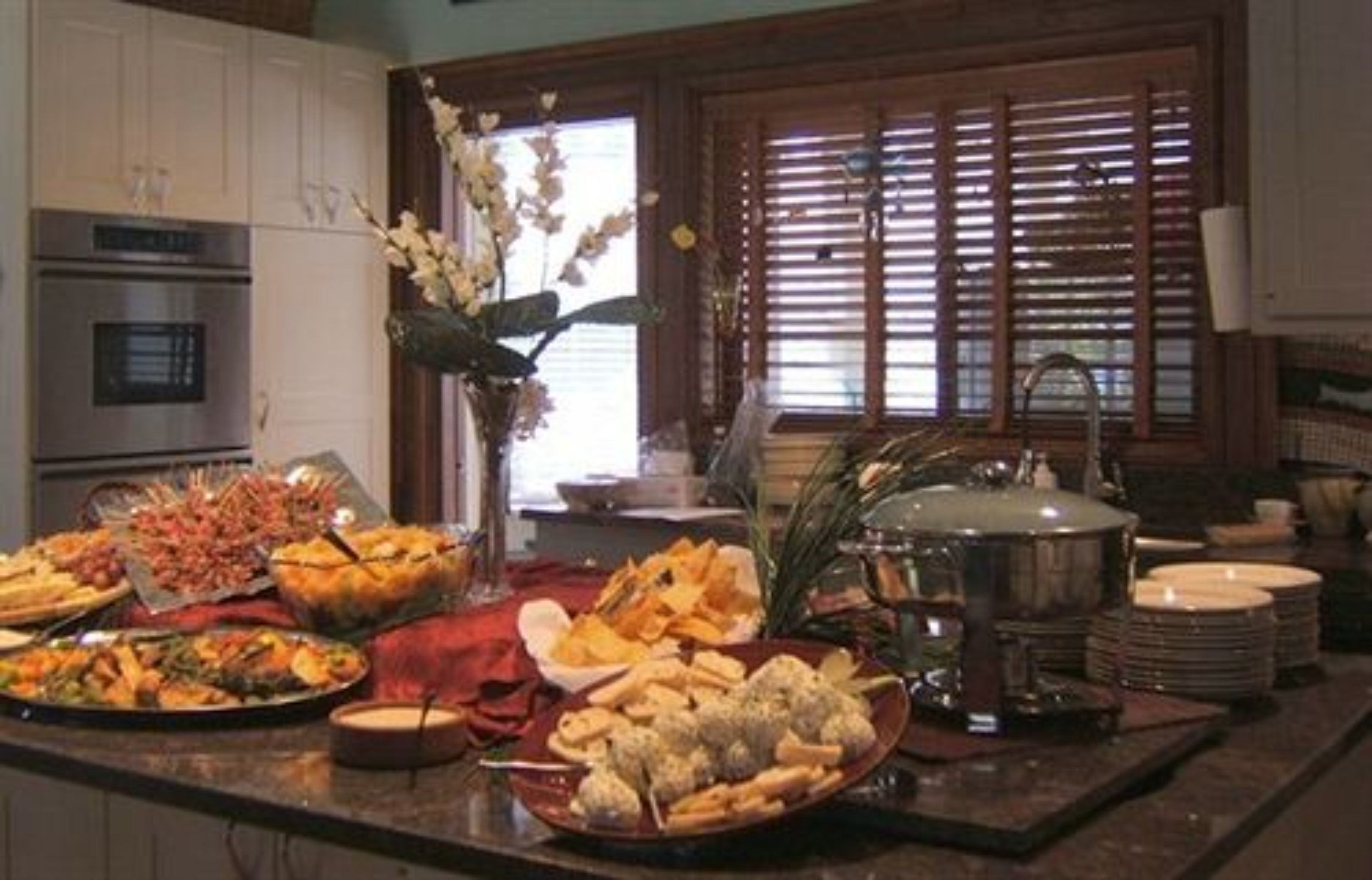 A buffet setup with various dishes and a large pot on the counter.