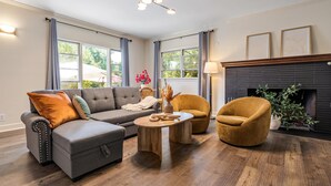 A modern living room with a sectional sofa, a round coffee table, and a fireplace.