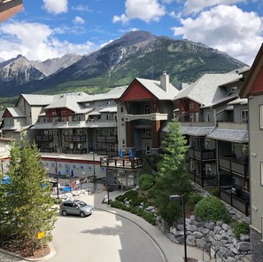 A multi-story hotel with a ski lift, surrounded by mountains and trees. - Lodges at Canmore (Canmore)