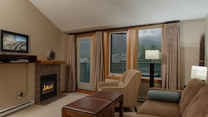 Una sala de estar acogedora con chimenea, televisor y vistas al exterior.