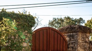 A wooden gate with a metal latch, set in a stone wall with ivy. - Seven Branches Venue and Inn (Sonoma)