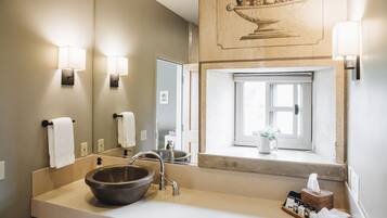 Ein Badezimmer mit großem Spiegel, einem Waschbecken, einem Fenster mit Aussicht und einem Handtuchhalter.
