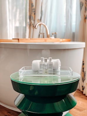A bathroom vanity with a green basin, a white sink, and three bottles of perfume. - The McClelland House (Napa)
