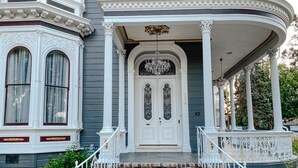 A grand house with a large porch, a staircase leading to the entrance, and a well-maintained garden. - The McClelland House (Napa)