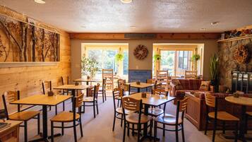 Un restaurante con mesas y sillas de madera, pared de piedra y un letrero que dice 'Killington'.