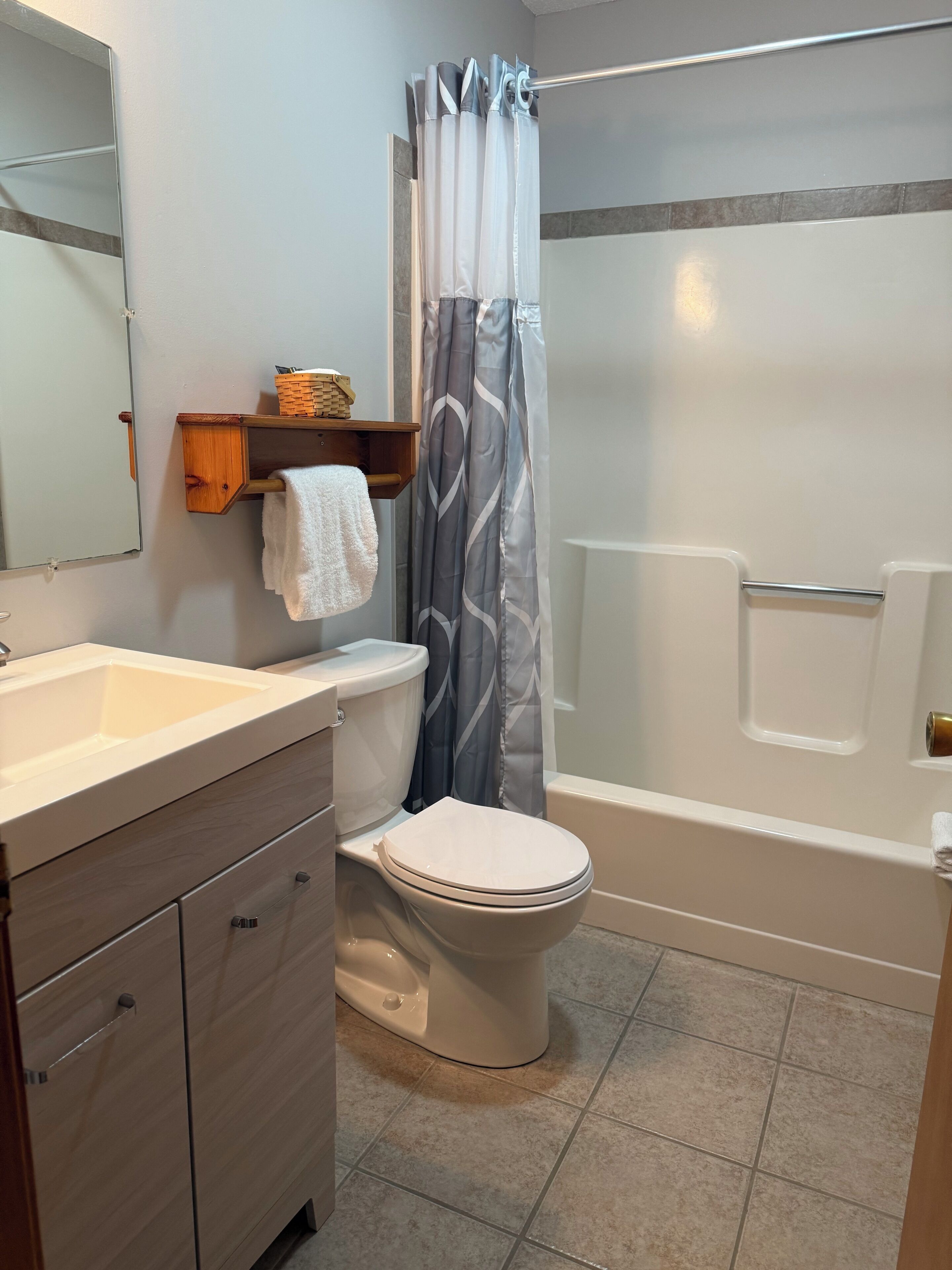 Een badkamer met toilet, wastafel en bad.