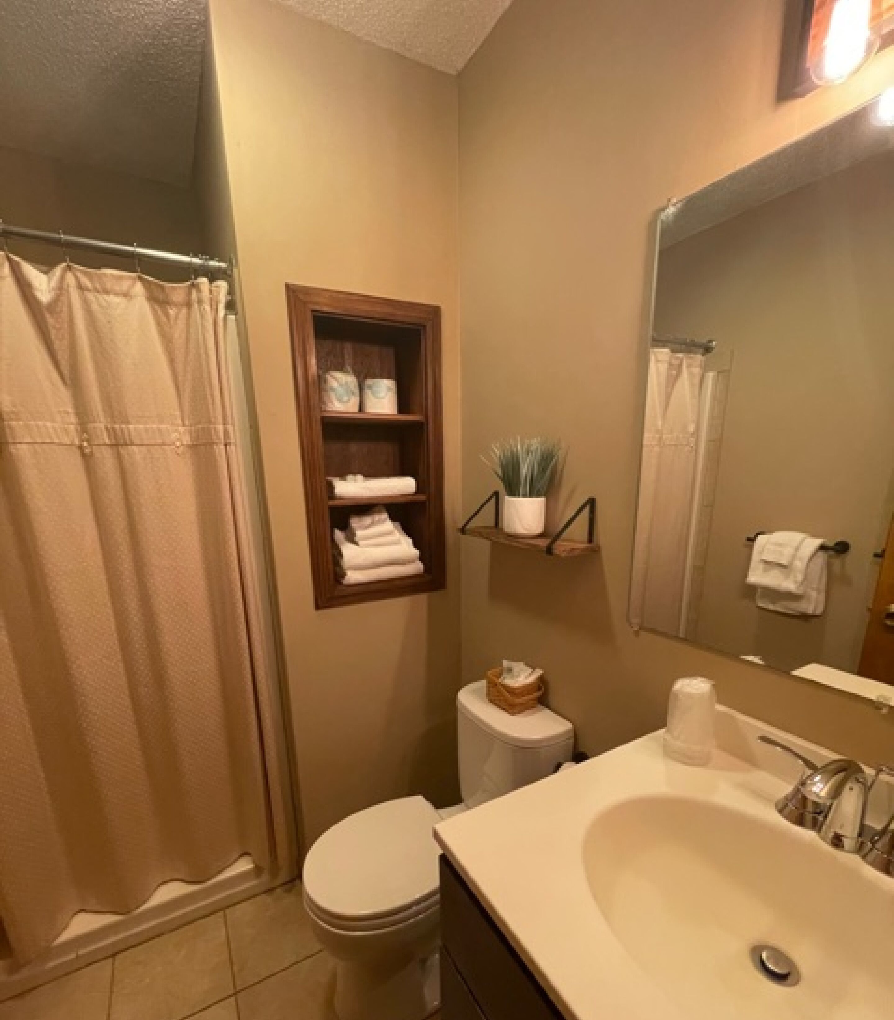 A bathroom with a toilet, sink, and shower curtain.