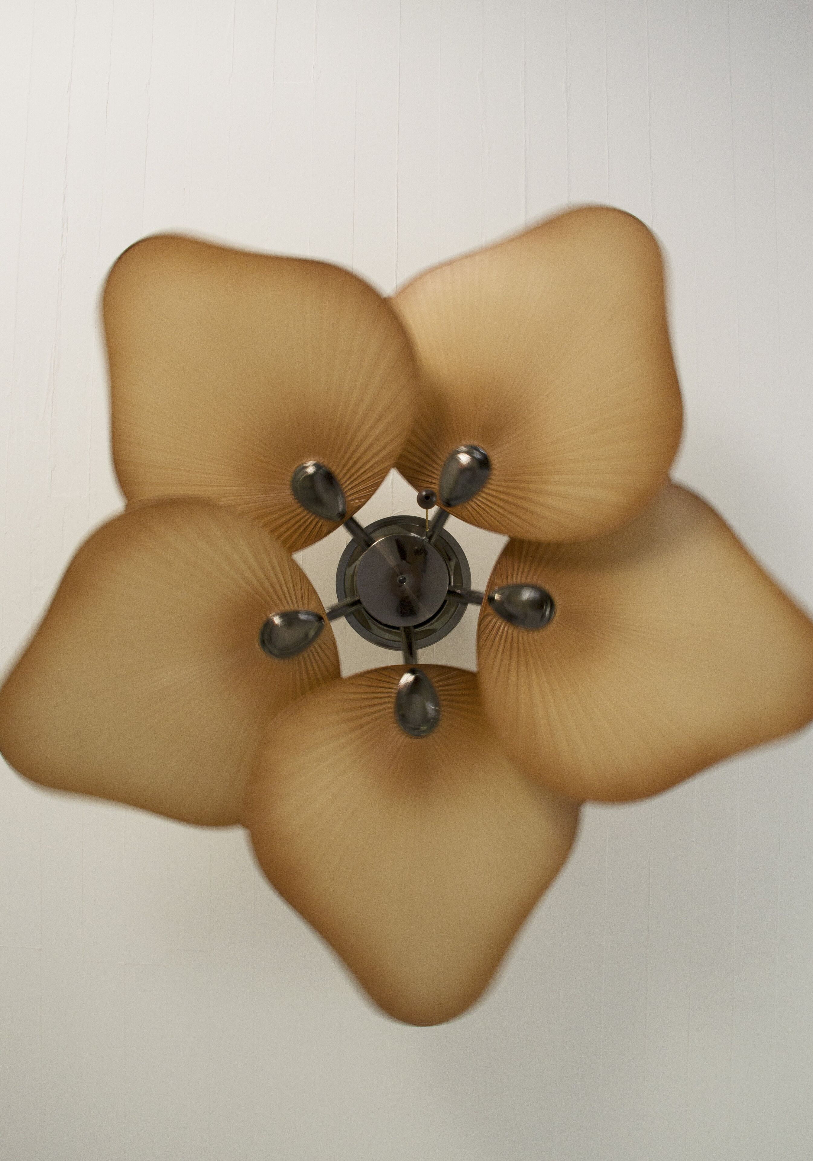 Um ventilador de teto com design de cinco pás e uma luminária central.