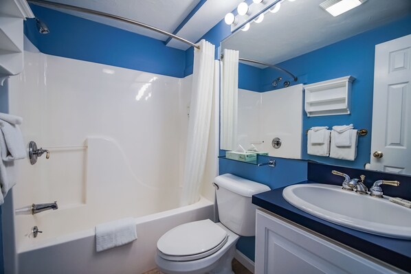 A bathroom with a bathtub, toilet, and sink. - InnSeason Resorts Captain's Quarters (Falmouth)