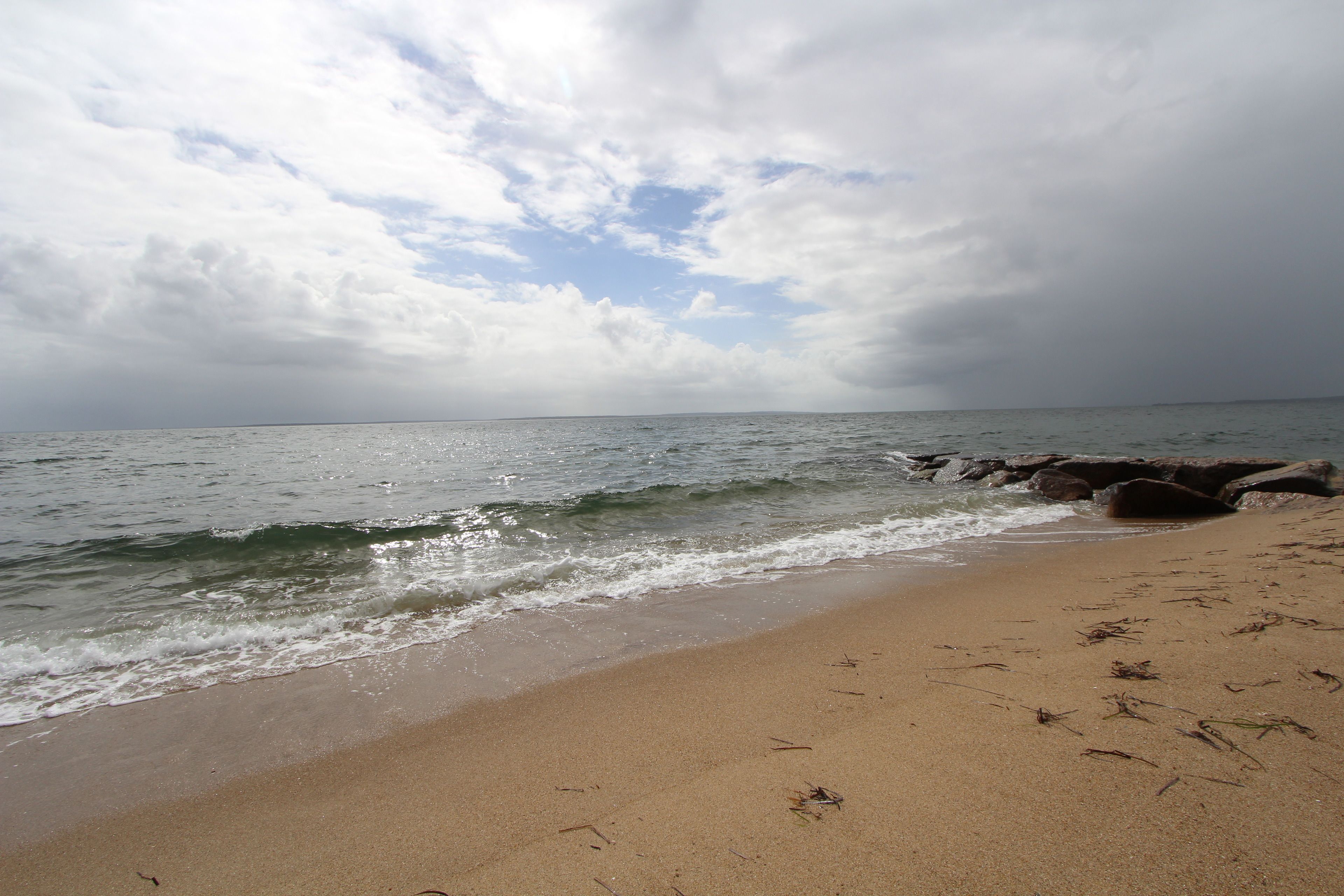 Ein Strand mit Sandstrand und Felsformationen.