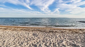 A sandy beach with gentle waves and a clear sky. - InnSeason Resorts Surfside (East Falmouth)