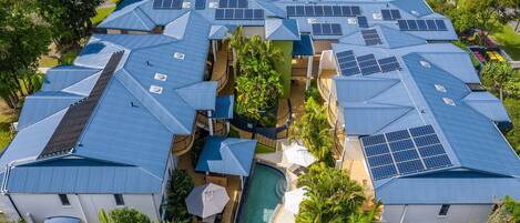 A residential complex with multiple houses featuring blue roofs and solar panels.