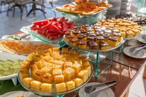 A buffet with various food items including cakes, fruits, and pastries. - Hotel Solar do Imperador (Porto Seguro)
