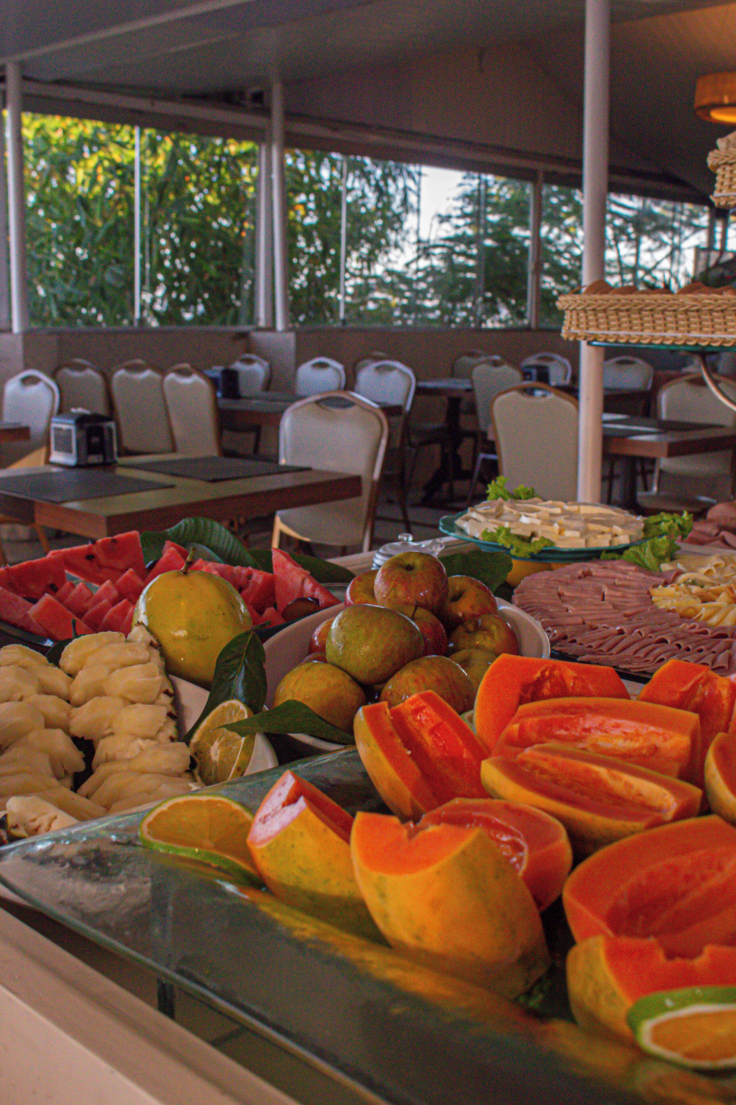 A buffet with various fruits and vegetables, including watermelon, apples, and oranges.