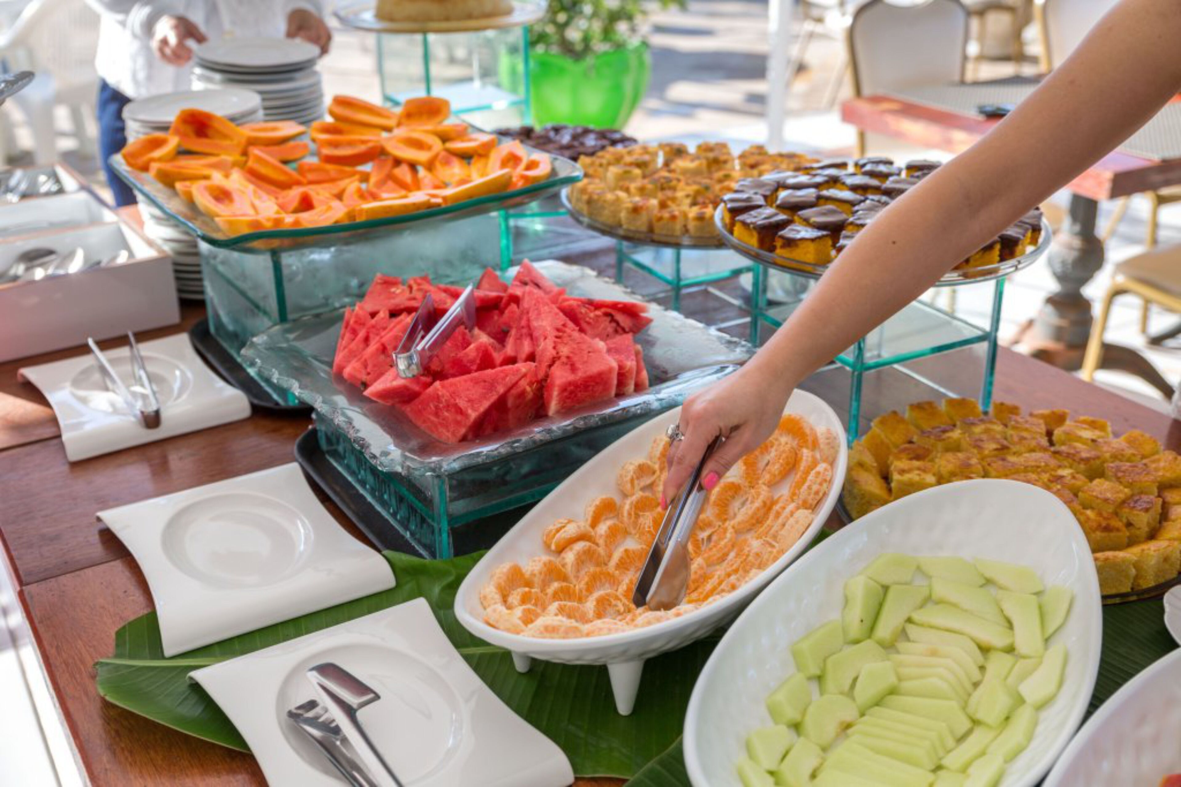 A buffet with various food items including watermelon, oranges, and other fruits.