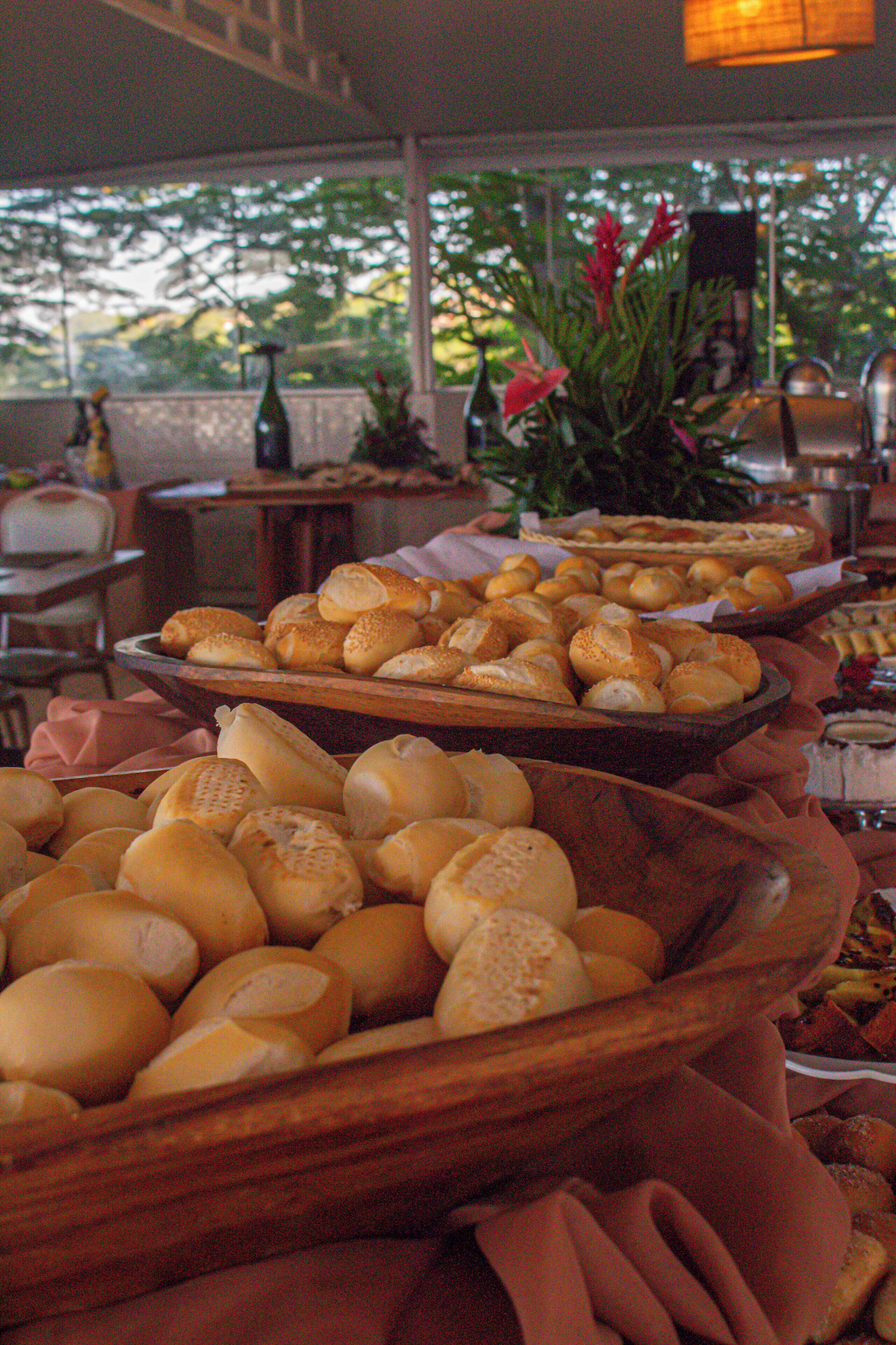 Una mesa de buffet con panes y pasteles varios.