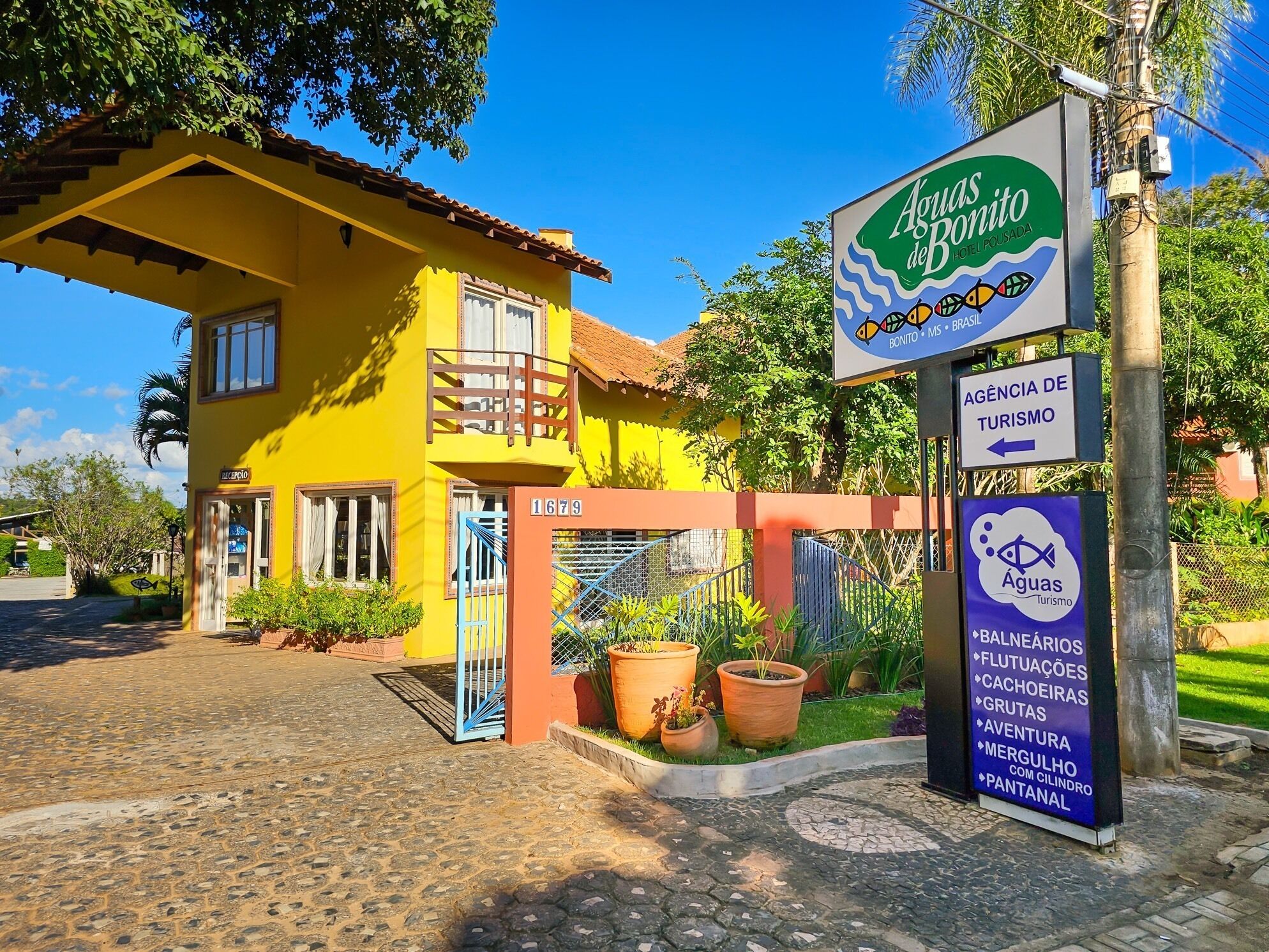 A yellow building with a sign for 'Aguas Bonito' and a tourism agency sign.