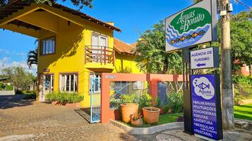Un edificio amarillo con un letrero que dice 'Aguas Bonito' y un cartel de agencia de turismo.
