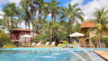 Una piscina cubierta, una piscina al aire libre, sombrillas